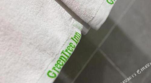 a white shirt with green writing on it at GreenTree Inn Yancheng Yandu District Hongxing Macalline Century Avenue in Yancheng