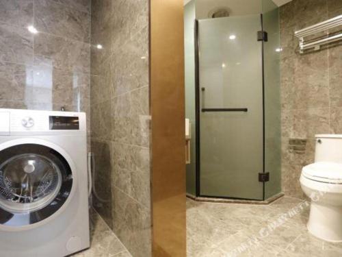 a bathroom with a washing machine and a toilet at Hujialou Hot Spring Hotel in Beijing