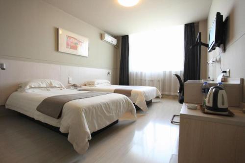a hotel room with two beds and a television at Zhangye Pinmu Hotel(Yuncheng Zhongyin Avenue Store) in Yuncheng