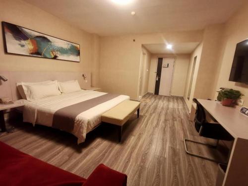 a hotel room with a bed and a desk at Zhangye Pinmu Hotel(Yuncheng Zhongyin Avenue Store) in Yuncheng