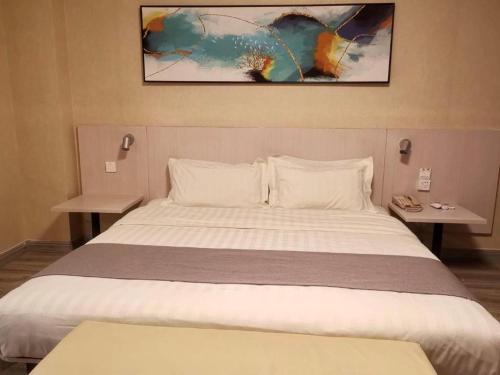 a bedroom with a large white bed with two tables at Zhangye Pinmu Hotel(Yuncheng Zhongyin Avenue Store) in Yuncheng