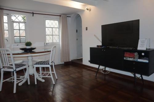 a living room with a table and a flat screen tv at Casita de Ocharan Miraflores a dos calles de Larcomar in Lima