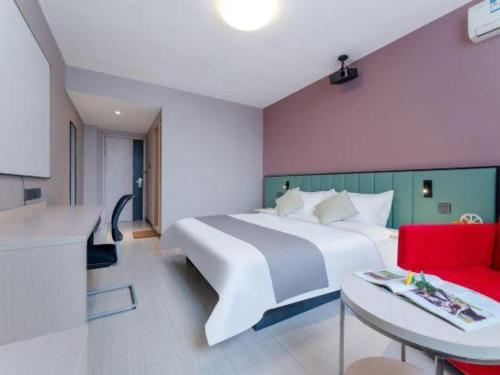 a bedroom with a large white bed and a red couch at Zhangye Pinmu Hotel(Yuncheng Zhongyin Avenue Store) in Yuncheng