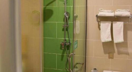 a shower in a bathroom with green tile at GreenTree Inn Qinhuangdao Changli County Guangyuan Life Square Duanyang Street East Section in Qinhuangdao