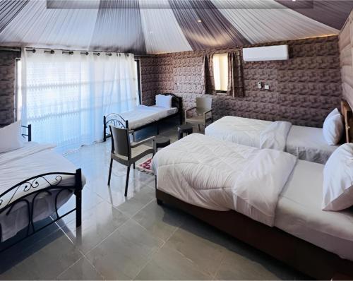 a bedroom with two beds and a table and chairs at Star Wars luxury camp in Wadi Rum