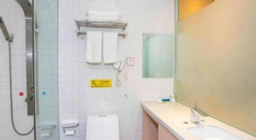 a bathroom with a toilet and a sink and a shower at 7 Days Inn Harbin West Railway Station in Harbin
