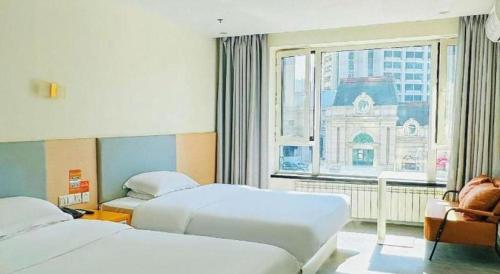a hotel room with two beds and a window at 7 Days Inn Harbin West Railway Station in Harbin