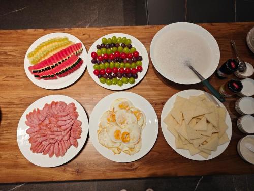 a group of plates of food on a wooden table at Xishuangbanna Sadu Lanmei Resort Hotel in Jinghong