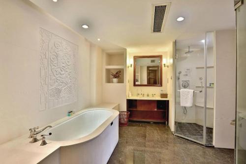 a bathroom with a tub and a shower and a sink at Dongyang Narada Grand Hotel in Yiwu