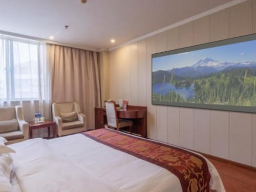 une chambre d'hôtel avec un lit et une télévision à écran plat dans l'établissement GreenTree Inn Wuxi Changjiang North Road Jincheng Road Express Hotel, à Fangqian