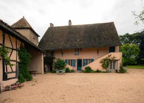 une grande maison blanche avec un toit dans l'établissement La Colombière Maison Familiale avec piscine proche Tournus, à Ratenelle