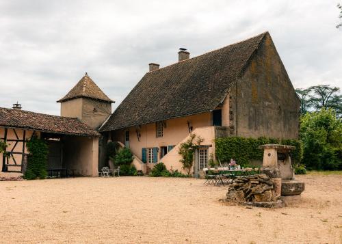 un ancien bâtiment avec une table devant lui dans l'établissement La Colombière Maison Familiale avec piscine proche Tournus, à Ratenelle