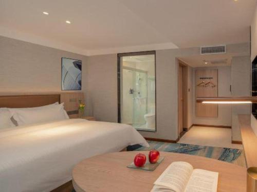 a bedroom with a bed and a table with tomatoes on it at GreenTree Inn Ganzhou Sankang Temple DaRunFa Express Hotel in Ganzhou