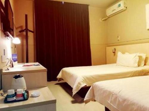 a hotel room with two beds and a sink at Jinjiang Inn Linyi Jinqueshan Road Branch in Linyi