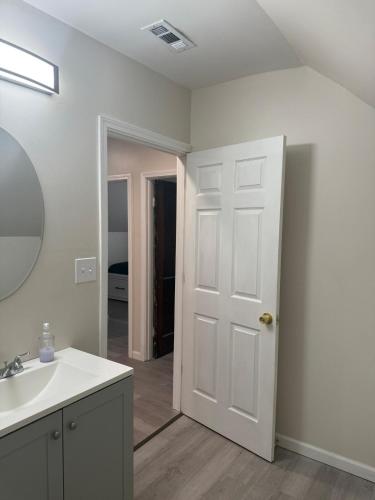 a bathroom with a sink and a white door at Downtown Golden Stairs in Buffalo