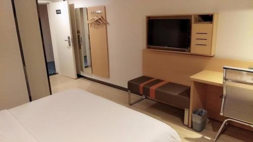 a hotel room with a bed and a television at 7 Days Premium Zunyi Conference Site Dingzikou in Zunyi