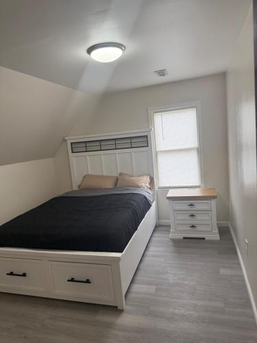 a bedroom with a bed and a nightstand and a window at Downtown Golden Stairs in Buffalo