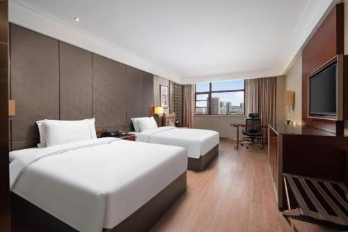 Postel nebo postele na pokoji v ubytování Echeng Hotel Wuhan Optics Valley Square Yangjiawan Metro Station