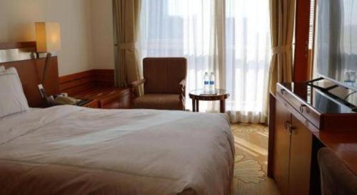 a hotel room with a bed and a chair at Jianguo Garden Hotel in Beijing