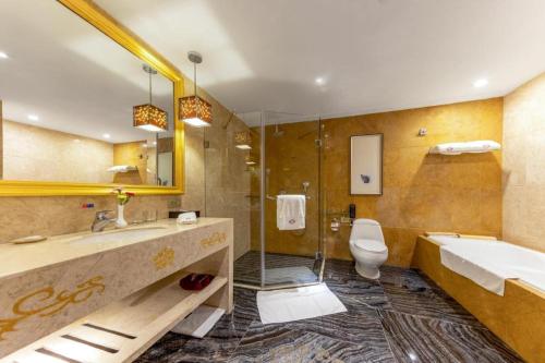 a bathroom with a sink and a toilet and a shower at Yihe Grand Hotel in Zhongshan