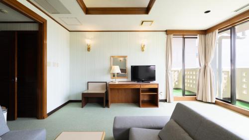 a living room with a television and a couch at Coral Palms in Amami