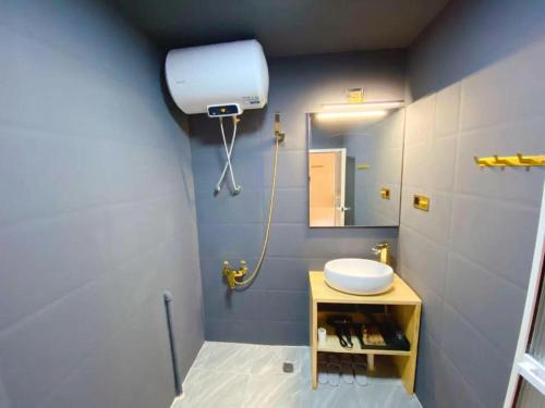 a bathroom with a sink and a mirror at Lantian Garden Hostel in Qingdao