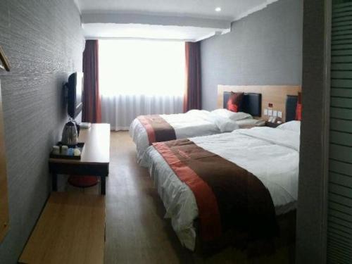 a hotel room with two beds and a window at Jun Hotel Jiangsu Nanjing Gulou District Gupinggang in Nanjing