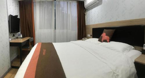 a bedroom with a large white bed and a television at Jun Hotel Jiangsu Nanjing Gulou District Gupinggang in Nanjing