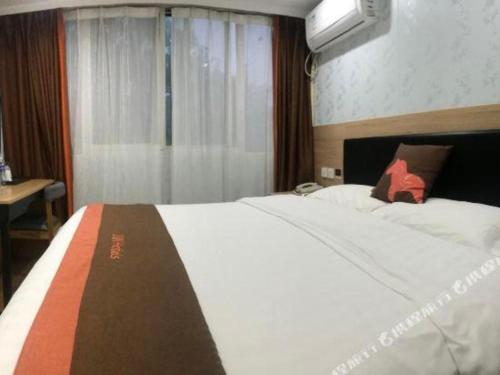 a bedroom with a large white bed and a window at Jun Hotel Jiangsu Nanjing Gulou District Gupinggang in Nanjing