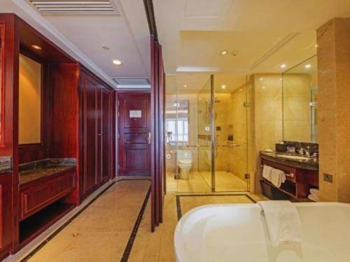 La salle de bains est pourvue d'une baignoire, d'une douche et de toilettes. dans l'établissement Grand Palace Resort, à Hsü-chia-ch'iao