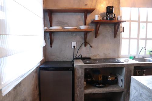 a small kitchen with a stove and a sink at Casita Guayaba in El Cuyo
