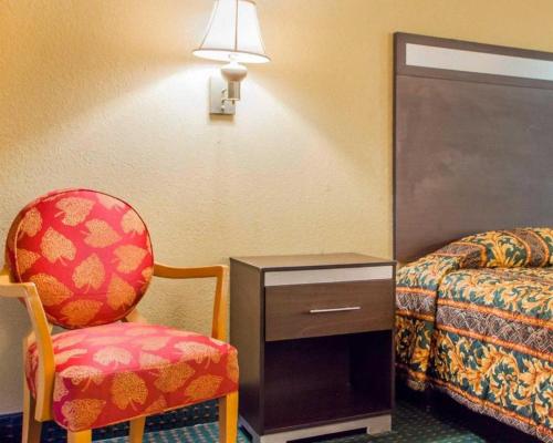 a room with a chair and a bed and a lamp at Rodeway Inn Mount Laurel Hwy 73 in Mount Laurel