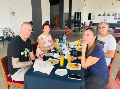 a group of people sitting at a table eating food at Hotel 198 Negombo in Negombo
