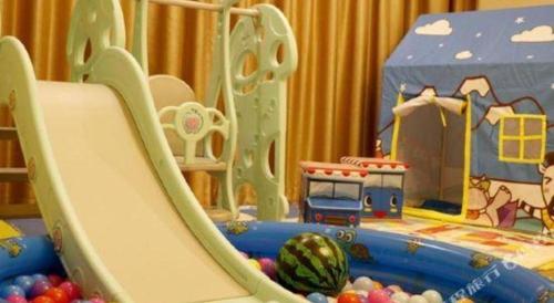 a slide in a childs play room with a toy at New Century Hotel Putuo Zhoushan in Zhoushan