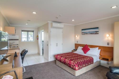 a bedroom with a bed and a living room at Avana Suites in Lower Hutt