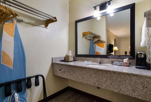 Un baño con lavabo y un espejo grande. en Quality Inn Brownsville, en Brownsville