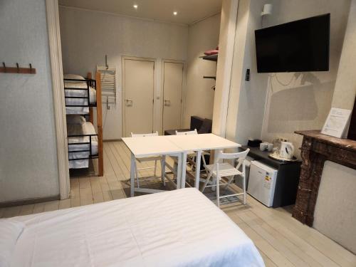 una habitación con una cama, una mesa y sillas en Albert - Rooms, en Malinas