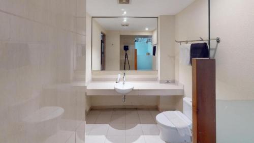 a bathroom with a sink and a toilet and a mirror at Nite and Day Batam Jodoh Square in Nagoya