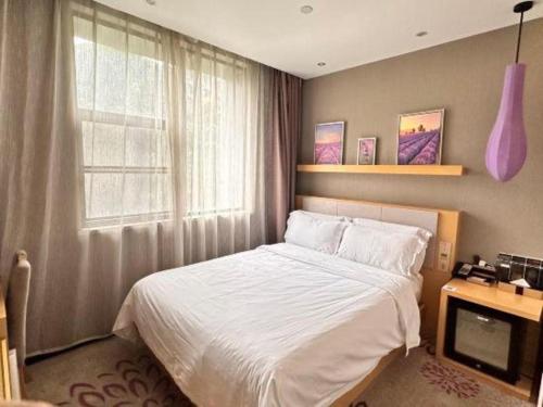 a bedroom with a white bed and a window at Lavande Hotel Guangzhou Tianhe Sports West Road Subway Station in Guangzhou
