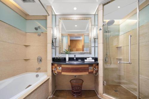 a bathroom with a sink and a tub and a shower at Wuhan Premier Mayflowers Hotel in Wuhan