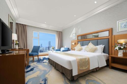 a hotel room with a large bed and a large window at Wuhan Premier Mayflowers Hotel in Wuhan