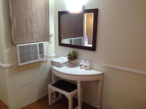 a bathroom with a white sink and a mirror at Ridgecrest Gardens Hotel in Olongapo
