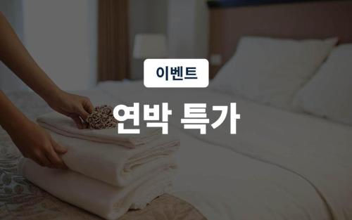 a person is making a mattress on a bed at Hotel Casa Suwon in Suwon