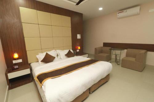 a bedroom with a large bed and a table and chairs at Hotel Gajur Palace in Itahari