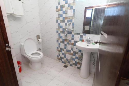 a bathroom with a toilet and a sink at Hotel Gajur Palace in Itahari