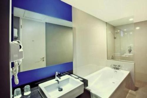 Un baño con dos lavabos y un espejo grande. en Indies Style Hotel Bandung, en Bandung