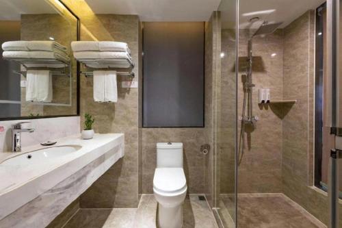 a bathroom with a toilet and a sink and a shower at Guilin Manhatton Hotel Tianjie in Guilin