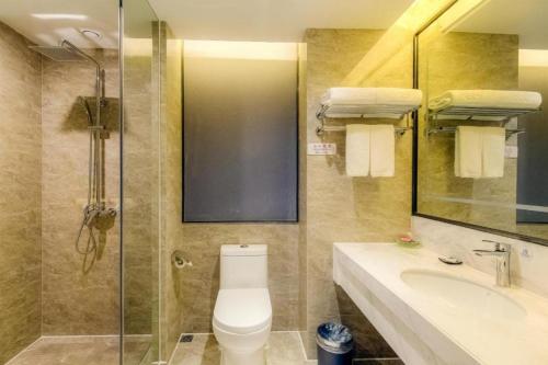 a bathroom with a toilet and a sink and a shower at Guilin Manhatton Hotel Tianjie in Guilin