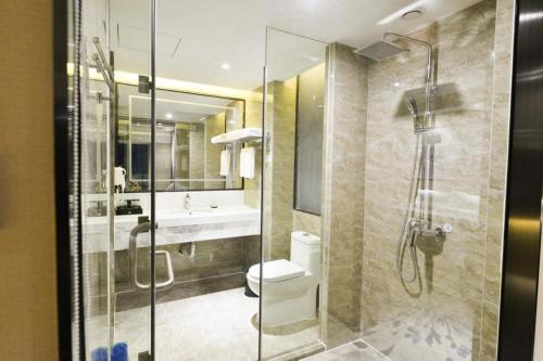 a bathroom with a shower and a toilet and a sink at Guilin Manhatton Hotel Tianjie in Guilin