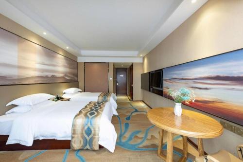 a hotel room with a large bed and a table at Guilin Manhatton Hotel Tianjie in Guilin